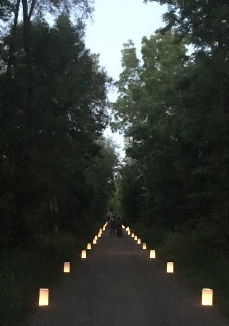 The lower escarpment rail trail at dusk. The trail is lined with candles in white bags.